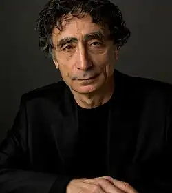 close-up of Gabor Maté wearing a black sport jacket, looking directly at the camera