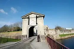 The Gate of Cassel, on a triangular pediment, incorporating the radiating sun of Louis XIV