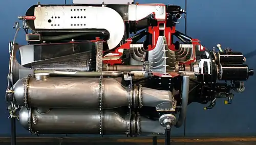 General Electric J31 with ten reverse-flow combustors. Compressed air flows between the 18-8 stainless steel outer casing and inner Inconel flame tube, then through a series of holes to the inside of the tube where it mixes with fuel. Burning continues along the length and is complete before reversing direction to the turbine.[86]