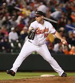 George Sherrill, in a white Baltimore Orioles uniform, in the middle of his throwing motion