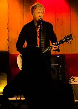 An older man playing a guitar