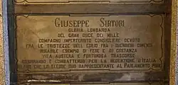 A marble gravestone on the wall of a crypt