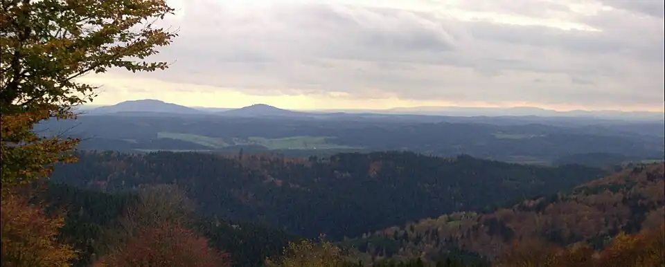View from the Simmersberg (781&nbsp;m) in the Thuringian Highland of the Gleichberge, 24&nbsp;km away. Right rear: the Rhön and the Kreuzberg (927.8&nbsp;m), 67&nbsp;km away. Centre, half right: the Ratscher Bergsee lake, 7&nbsp;km away