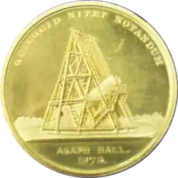 A gold medal, featuring an image of a telescope. Engraved with 'Asaph Hall 1979' and 'quicquid nitet notandum'