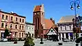 Main church and an 18th-century timber frame tavern on the marketplace in Golub
