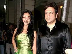 Govinda in a black satin shirt with Amrita Rao, a young actress