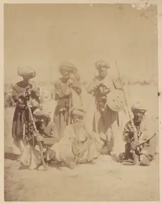 Afghan mountain tribesmen, likely Pashtuns, holding shields and wearing traditional clothing, around 1879–1880.