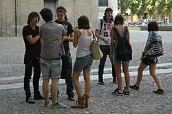 Image 44Teenagers in Italy wearing graphic tees, plaid shirts, cutoff shorts, and studded accessories popular early in the decade, 2010. (from 2010s in fashion)
