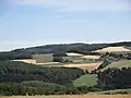 Blick from the direction of Obertiefenbach über das Hasenbachtal ostnordostwärts of the Weißler Höhe (rear); rechts am Ringmauerhang der Obertiefenbacher Weiler Spriestersbach
