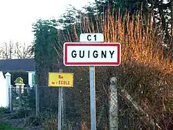 A road sign at the entry to Guigny