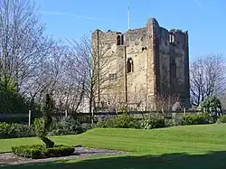 roofless stone castle keep in parkland]