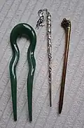 modern hair sticks made of acrylic and metal, right one references a viking age design from Hedeby