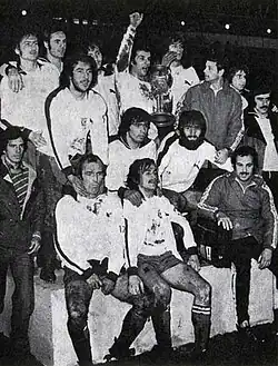 Black and white photograph of a team of men posing with a trophy