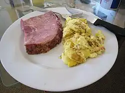 A thick-cut ham steak and scrambled eggs