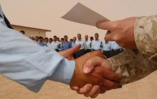 Shaking with the right hand while delivering a certificate with the left