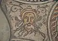 Detail from the 'Hunting Dogs Mosaic'. It was one of two mosaics found under Dyer Street, Cirencester in 1849, and was a driving force in the foundation of the first Corinium Museum. The image is of Oceanus, a sea god.[12]