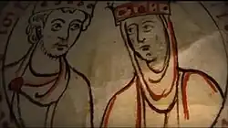 A bearded young man and a veiled young woman look at each other