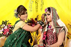 Image 19Relatives decorating the bride with traditional wedding turmeric in a Bangladeshi Gaye Holud ceremony in Dhaka. (from Culture of Bangladesh)