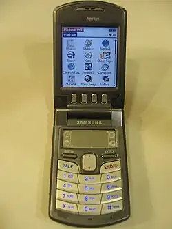 Photograph of an open flip phone with its screen on