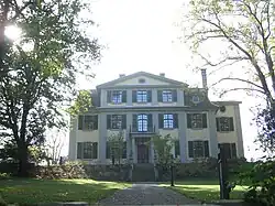 Three-storey mansion surrounded by trees and gardens