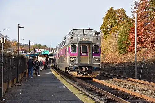 A passenger train arriving at a station with a low-level side platform and two tracks