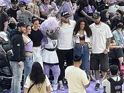 Fans pose courtside with Violet, the San Francisco Valkyries’ purple bird mascot, during a WNBA game at Chase Center.