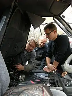 Tyson Jerry and mechanics inspecting the custom fuel system of the Driven to Sustain van in Upper Laberge, Yukon.