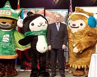 Jacques Rogge posing with three Vancouver 2010 mascots.