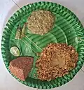 Batti (baked wheat balls), served whole and in crushed form, with Jalgaon Bharit—a smoky, spicy mashed brinjal dish—traditionally accompanied by green chillies and lemon