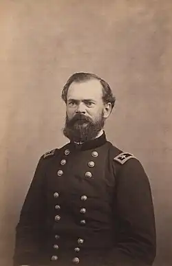 1860s photograph of a bearded white man wearing a dark blue military uniform facing the camera