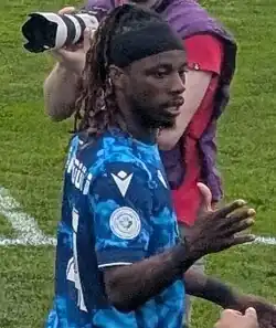 Right profile of a man with right hand raised to give dap
