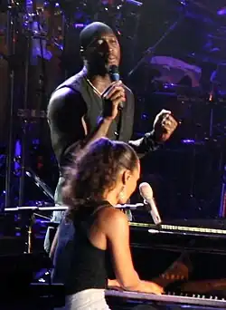 Paul performing with Alicia Keys in the foreground, 2006