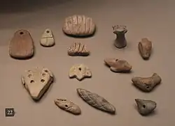 Accounting tokens of various shapes: jar, ram's head, bread and unidentified objects. Susa, ca. 3800-3100 BC. Louvre Museum.