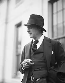 Picture of Barrymore outside, from the waist up, pensively smoking a cigarette and facing to the left