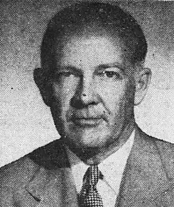 Black-and-white photograph of J. Howard Pyle from the chest up. He wears a suit jacket, white button-up shirt, and a necktie. His hairline is receded toward the back of his head.