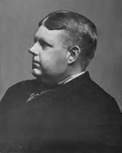 Middle-aged white man in profile; he has short hair, round cheeks, and a heavy brow