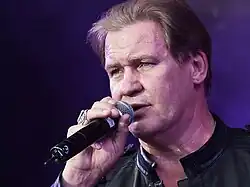 Close-up photo of Johnny Logan performing on stage in 2010.