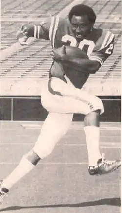 A black and white photograph of a man wearing an American football uniform