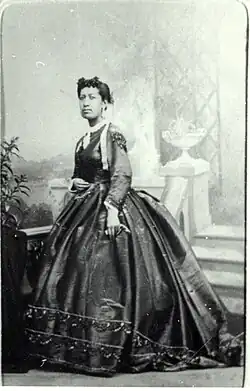 Black-and-white photograph of an indigenous Mexican woman wearing a large court dress.