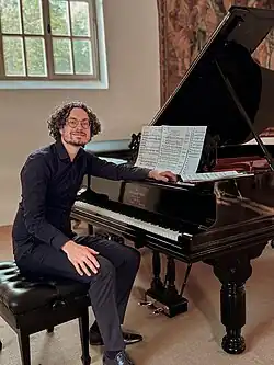 Joshua Rupley sitting at an 1890 Steinway grand piano in Gut Bannacker, Germany