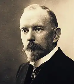 Portrait of French author Jules Renard with a beard, wearing a dark suit.