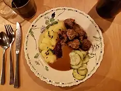 Swedish meatballs with pickles, lingonberry jam, mashed potatoes, and gravy