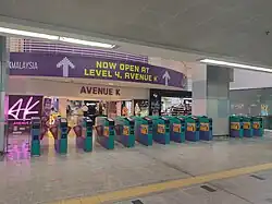 The fare gates to/from the station with the Avenue K shopping mall's concourse beyond