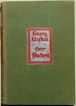 Photo of a green book cover with the red text "Franz Kafka Der Prozess"