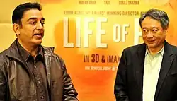 Ang Lee, a grey-haired man, looking at Haasan (who is speaking)