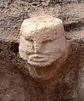 Carved head in structure AB (on site)