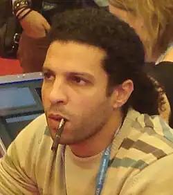 A middle-aged man with a ponytail looking towards something to the left of the camera