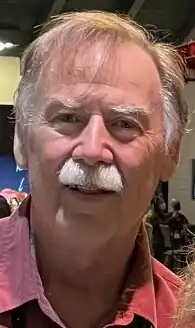 Williams with gray mustache wearing a red shirt