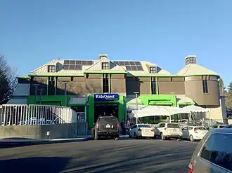 Tan building with bright green highlight and a complex roofline