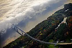 Aerial view of a bridge approaching a fog-covered river